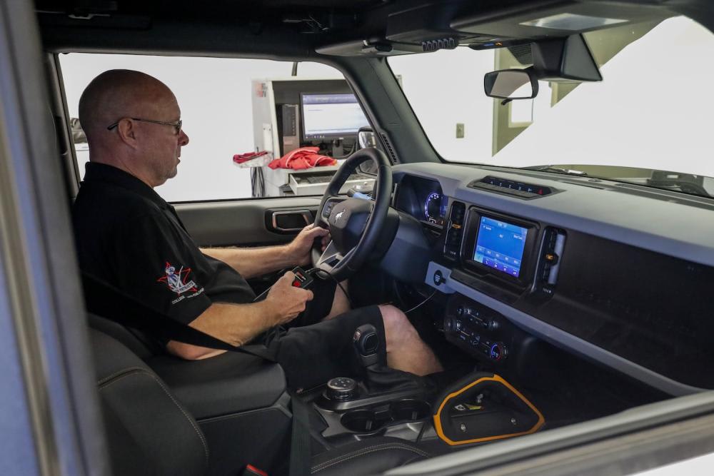 Looking through the passenger window of 2021 Ford Bronco as an engineer captures data from the vehicle undergoing dyno testing at K&N Engineering 